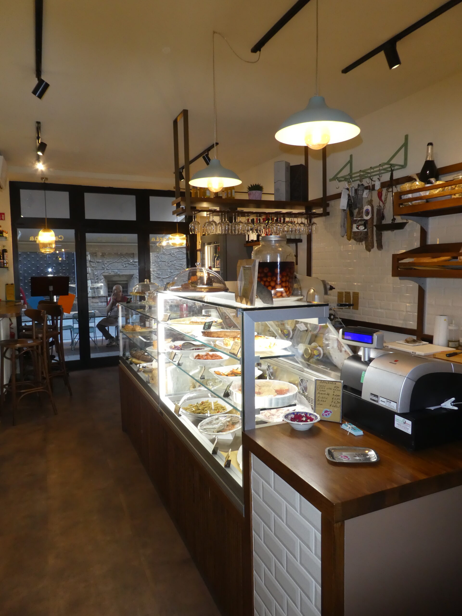 Progetto su misura: ottimizzazione di piccoli spazi con arredi professionali e soluzioni espositive che integrano bottega, gastronomia e cucina.